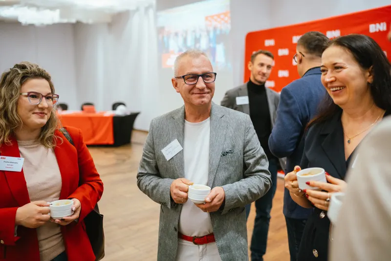 Uczestnicy rozmawiają przy kawie przed spotkaniem